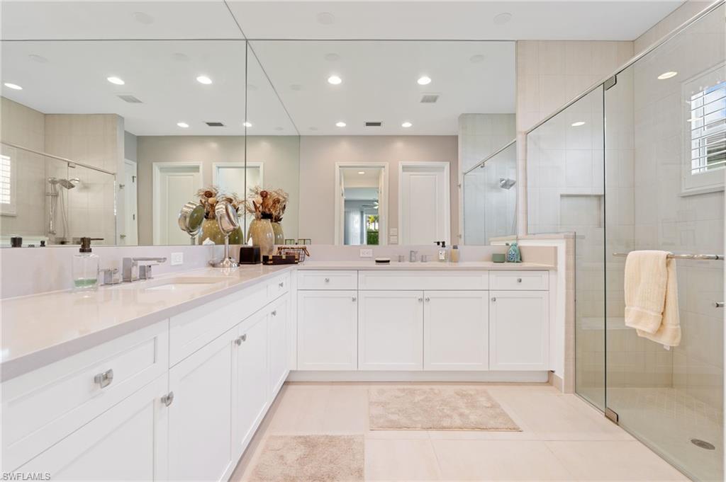 Primary bathroom feature dual sinks and wall to wall mirrors