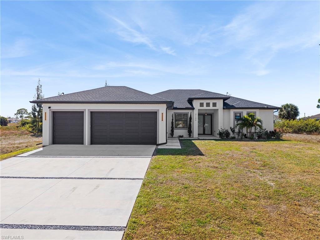 Prairie-style home with concrete driveway, an attached garage, a front yard, stucco siding, and a shingled roof