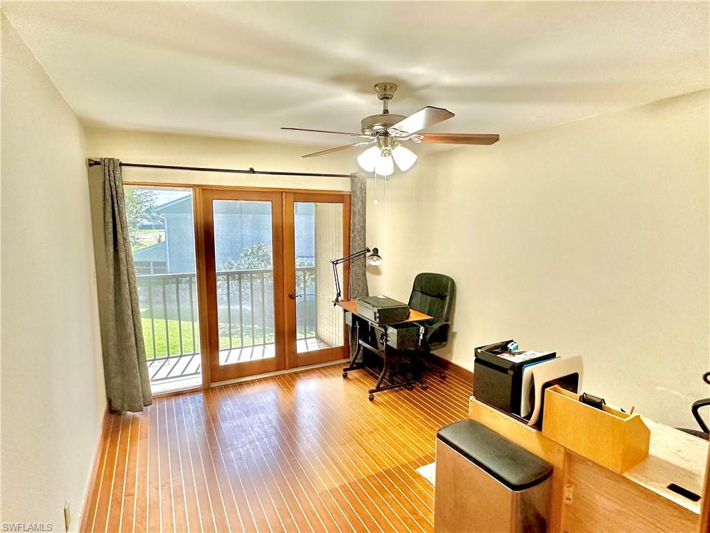 Room featuring wood-finish flooring and a ceiling fan with integrated lighting