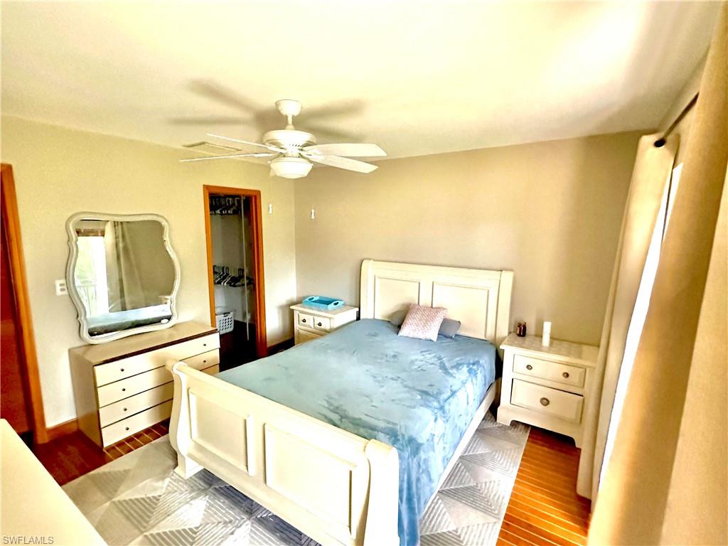 Bedroom featuring wood-finish flooring, a ceiling fan, and a neutral wall color
