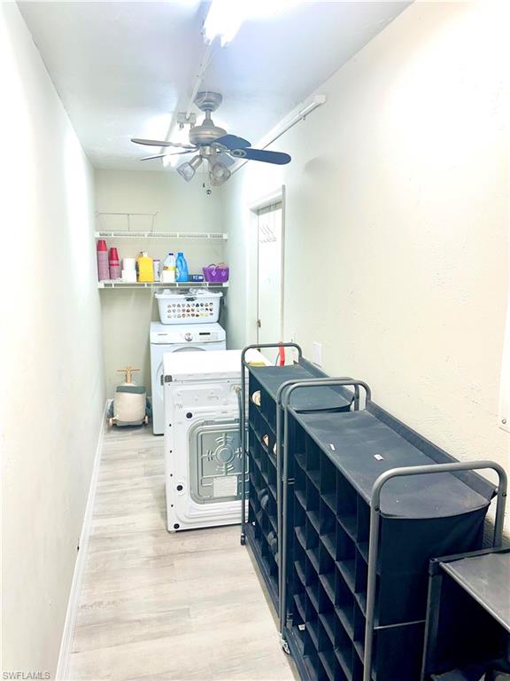 Utility room featuring wood-finish flooring, overhead track lighting, and a ceiling fan