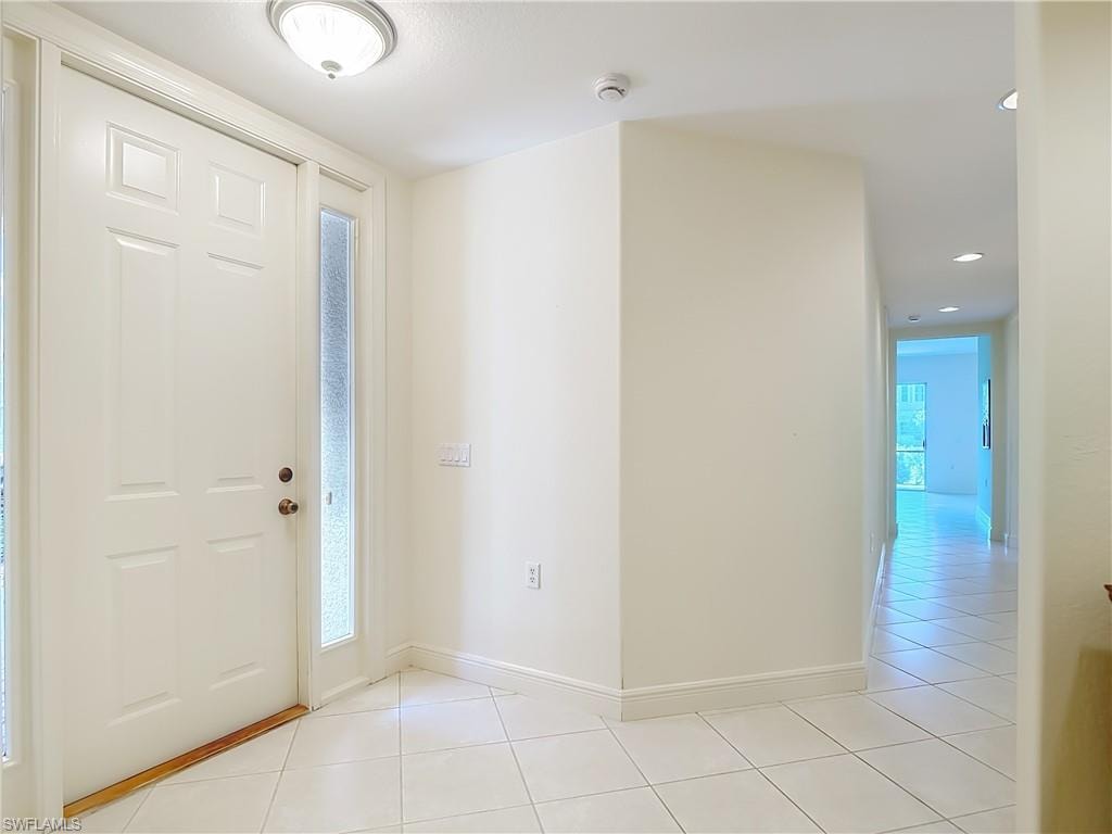 Entryway featuring a white paneled door with a sidelight, ceramic tile flooring, and a flush mount ceiling light