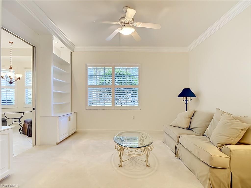 Light-toned room featuring a ceiling fan, crown molding, and built-in shelving with lower cabinetry