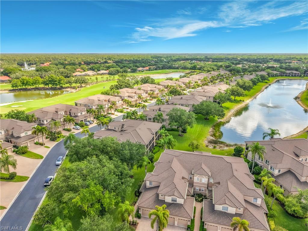 Aerial perspective showcasing multiple properties, a golf course, and two large water features with fountains