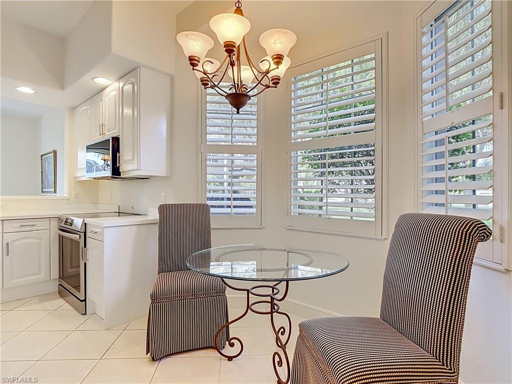Breakfast nook featuring a decorative chandelier and dual windows with white plantation shutters