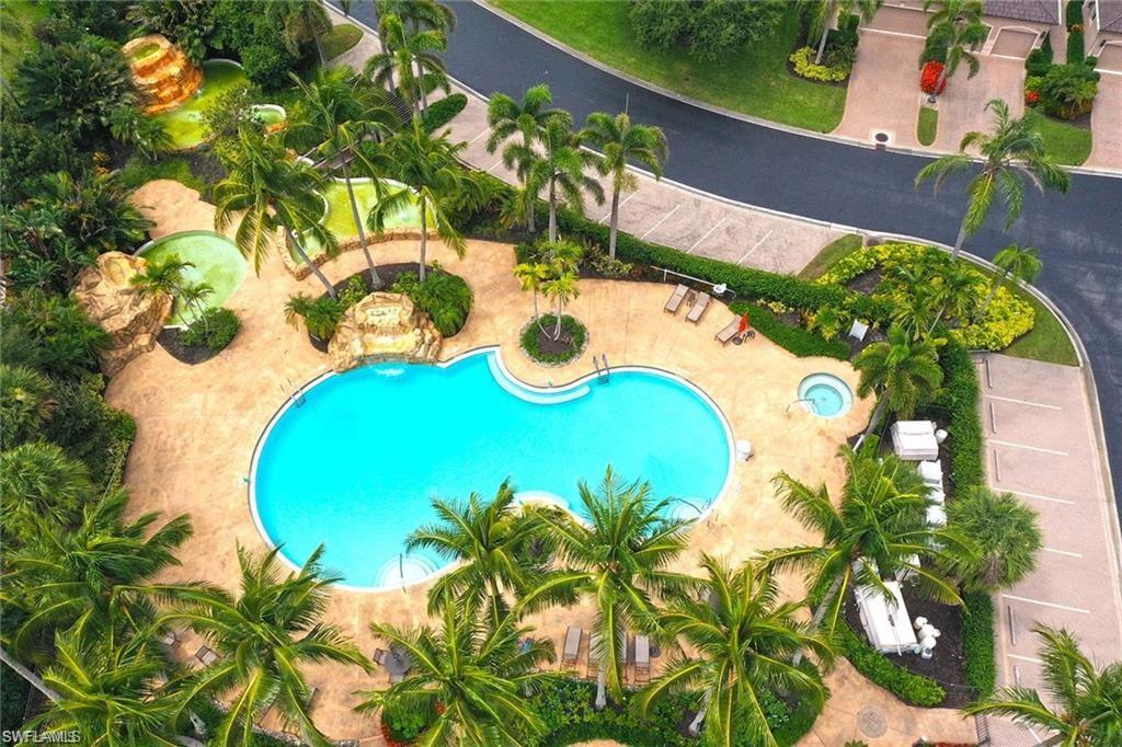 Resort-style pool area featuring a large freeform swimming pool, integrated spa, and waterfall rock features