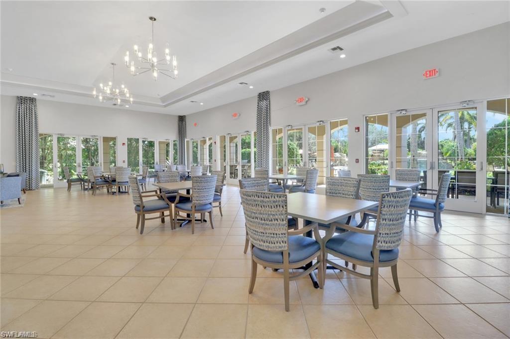 Spacious gathering area featuring large format tile flooring, multiple sets of French doors, and contemporary chandelier lighting