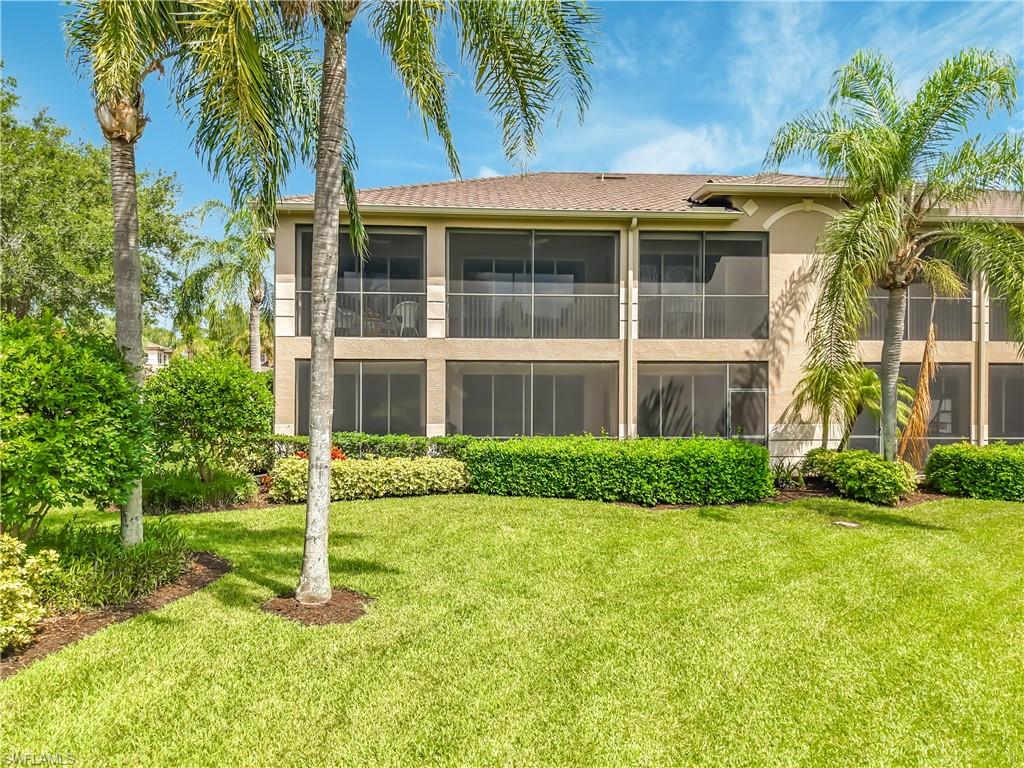 Expansive green lawn with mature palm trees and manicured shrubbery