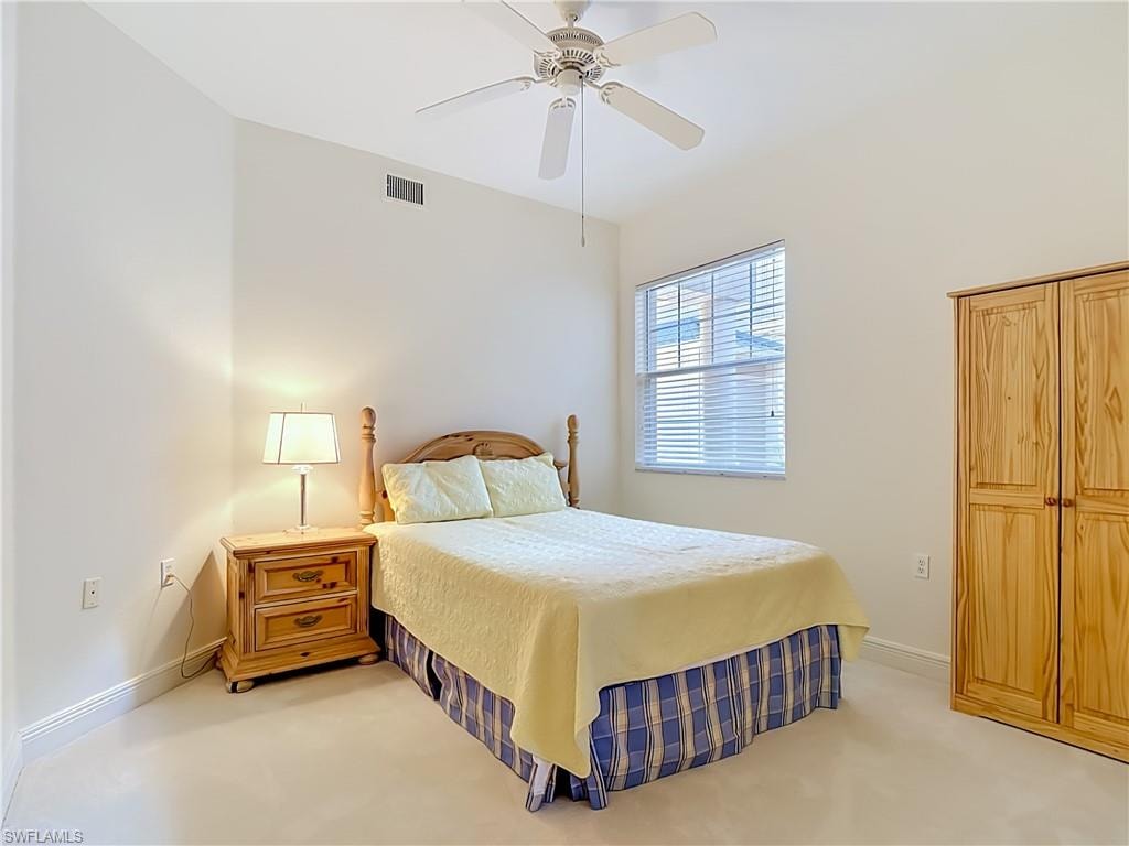 Neutral-toned room featuring a window with blinds, ceiling fan, and light-colored flooring