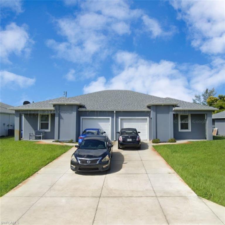 Duplex structure featuring a light gray exterior finish and a dark gray shingle roof