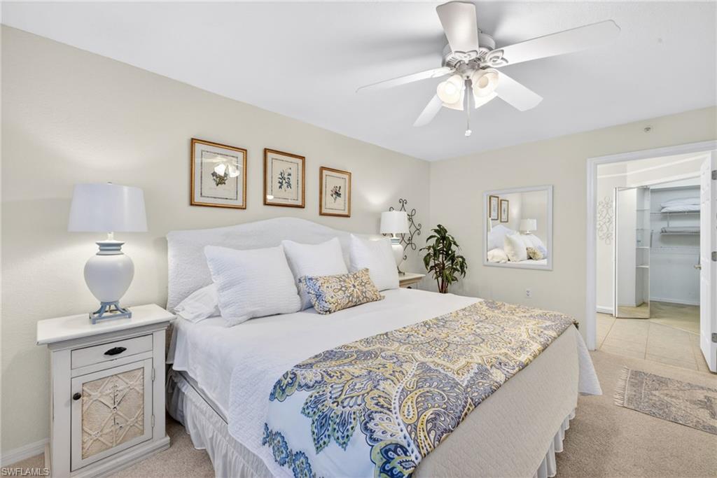 Primary Bedroom featuring a ceiling fan with integrated lighting, a mirrored closet door, built-in closet shelving, and light-toned walls