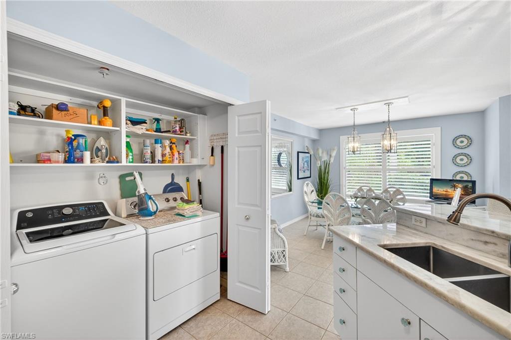Integrated laundry closet with built-in shelving, front-loading washer and dryer, and bi-fold doors
