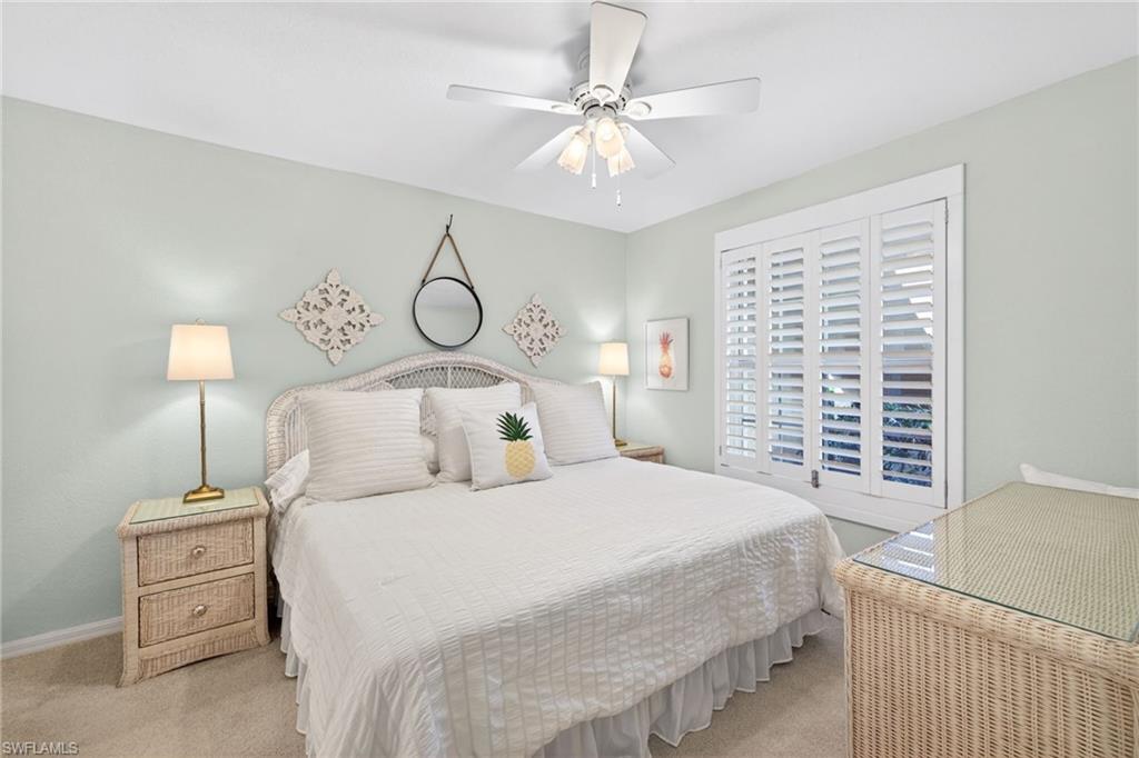 Bedroom featuring a window with white plantation shutters, a ceiling fan, and light-colored wall paint