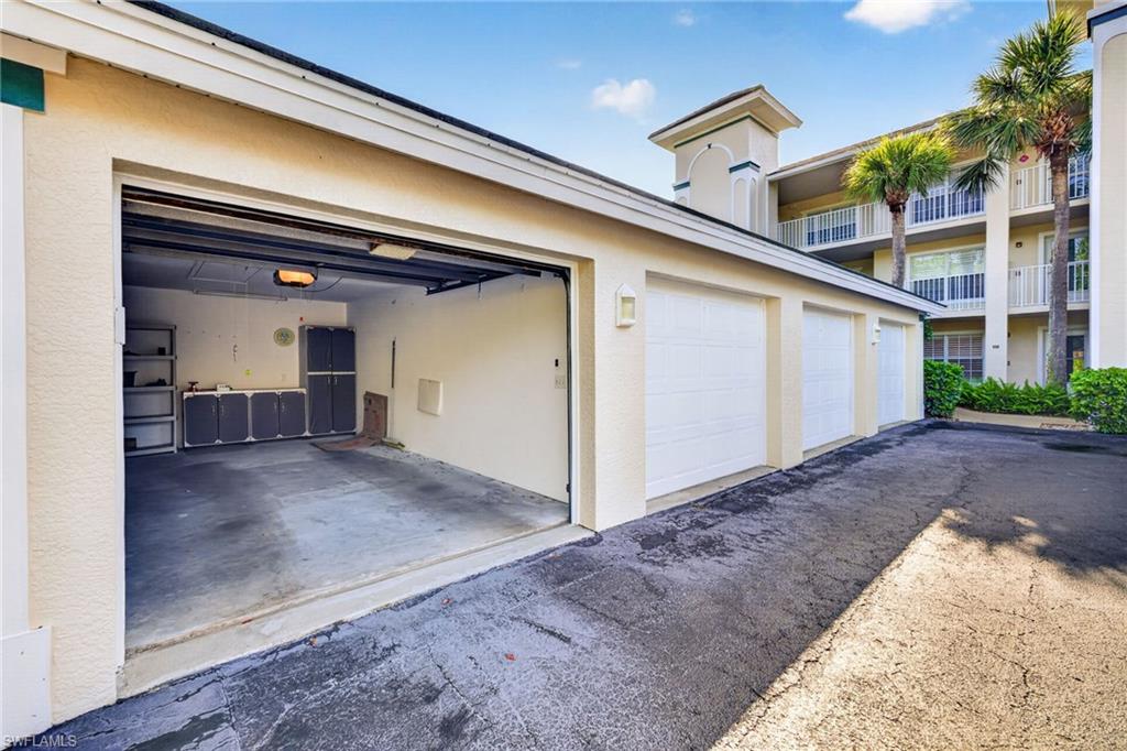 Attached garage with an open bay, concrete flooring, and built-in storage cabinetry
