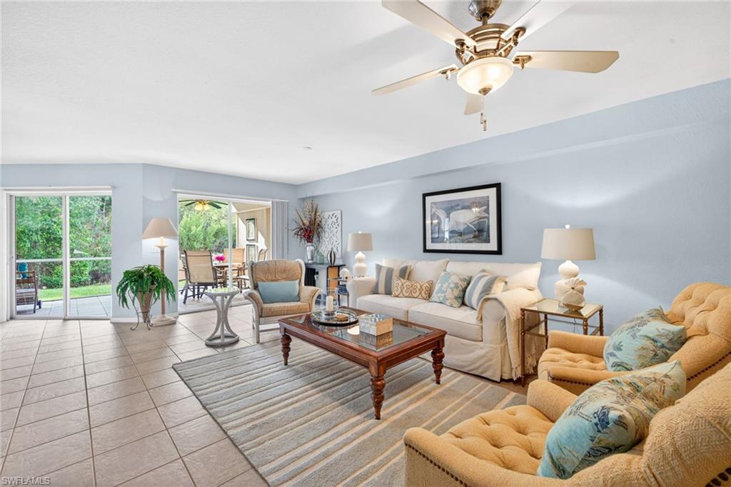 Spacious living area featuring tile flooring, ceiling fan with integrated lighting, and light blue wall tones