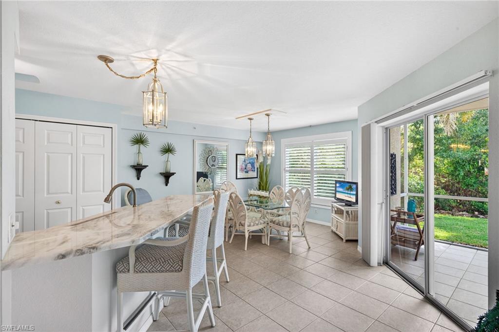 Spacious breakfast bar with a stone countertop, tile flooring, and direct access to an outdoor patio through sliding glass doors