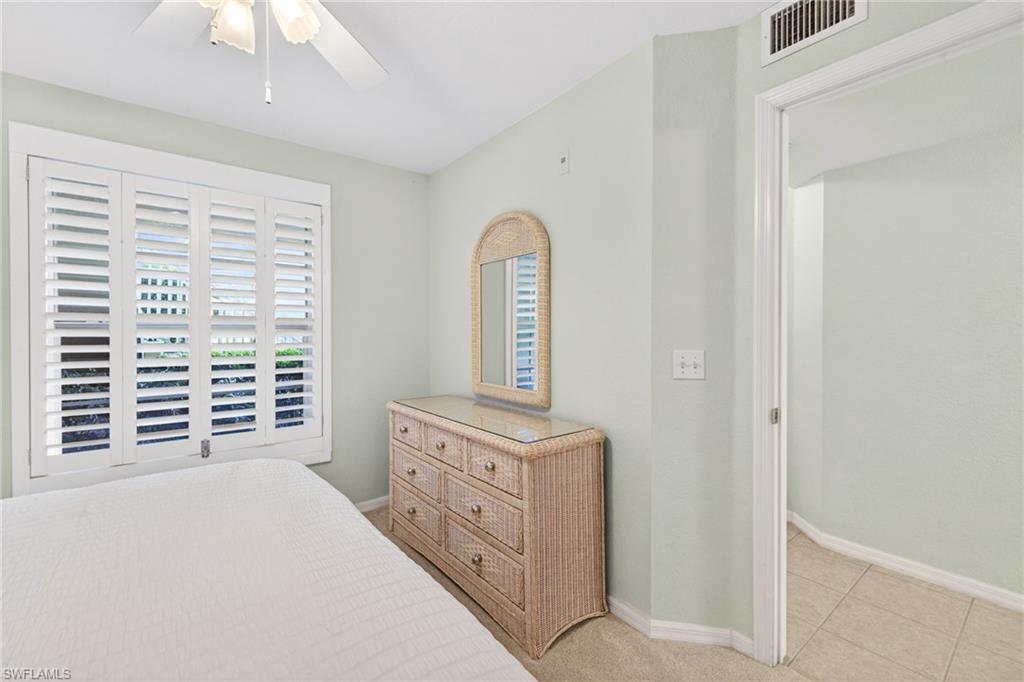 Window with white plantation shutters and a ceiling fan with light fixture