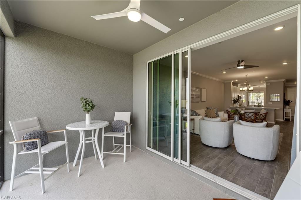 Sunroom featuring ceiling fan with notable chandelier