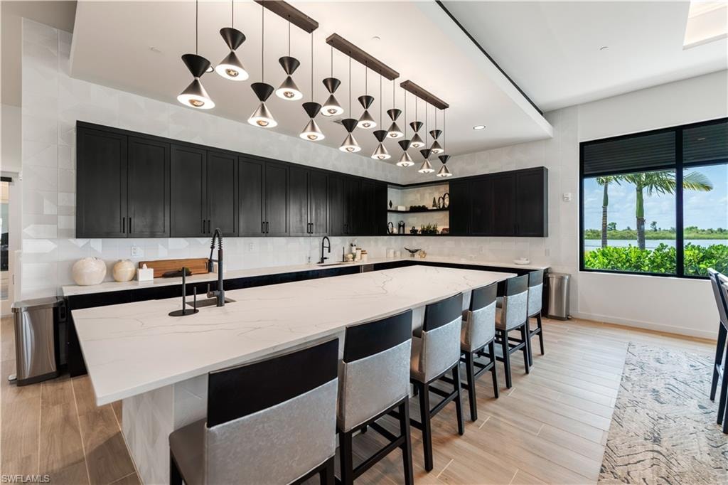 Kitchen with pendant lighting, light stone counters, and tasteful backsplash
