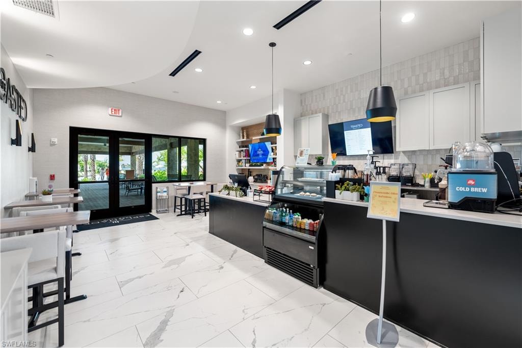 Kitchen with pendant lighting, white cabinetry, french doors, and light tile patterned flooring