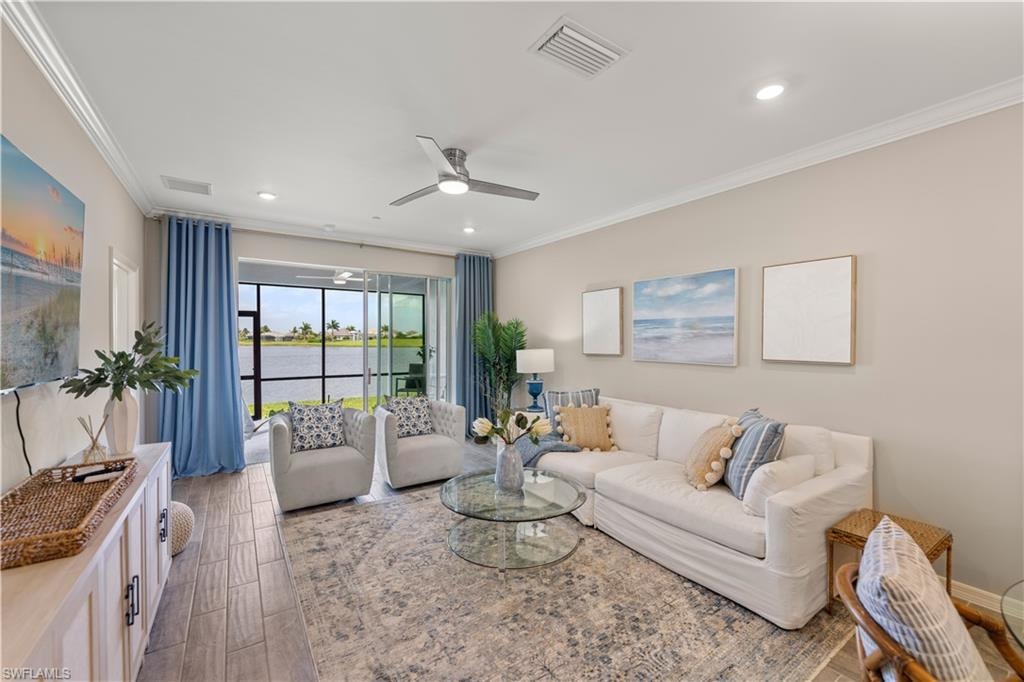 Living room featuring hardwood / wood-style flooring, ceiling fan, and crown molding