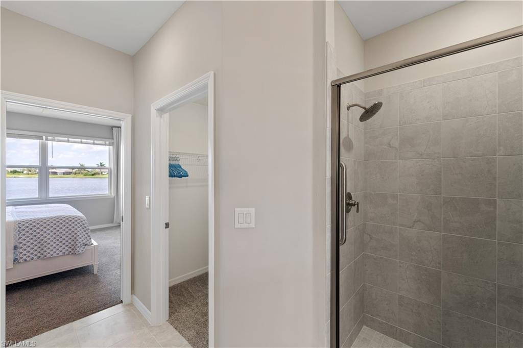 Bathroom featuring walk in shower and tile patterned flooring