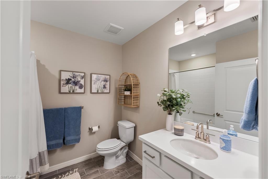 Bathroom with vanity, toilet, and tile patterned floors