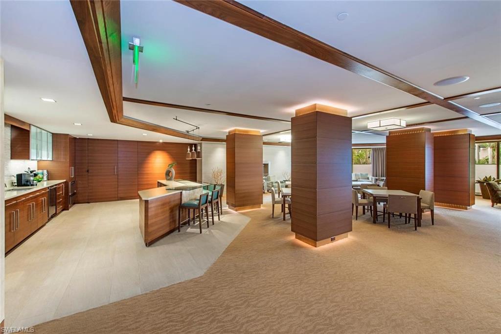 Spacious common area featuring wood-finish paneling, coffered ceilings, and recessed lighting