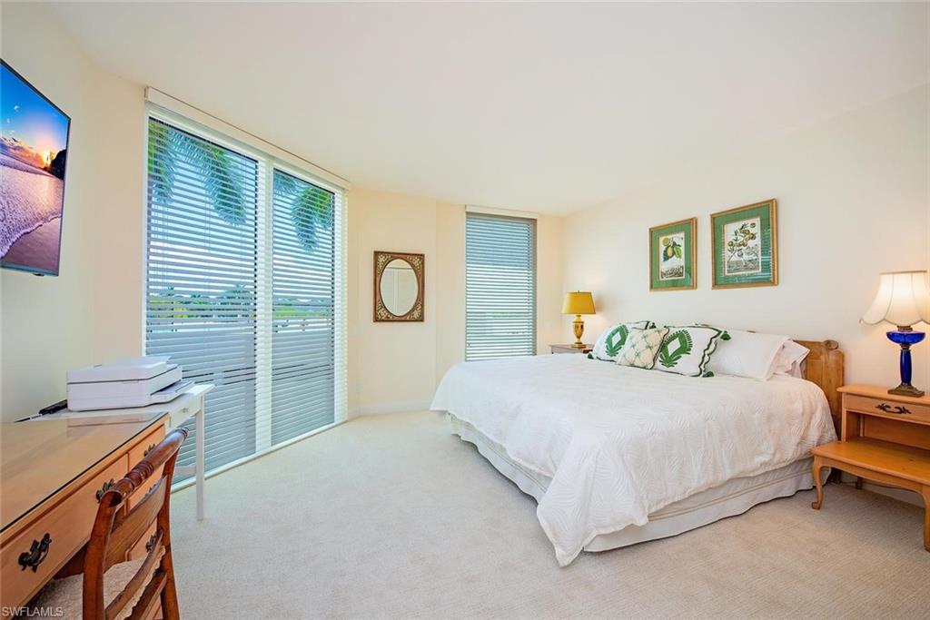 Bright interior room featuring a large sliding glass door with horizontal blinds and a secondary window