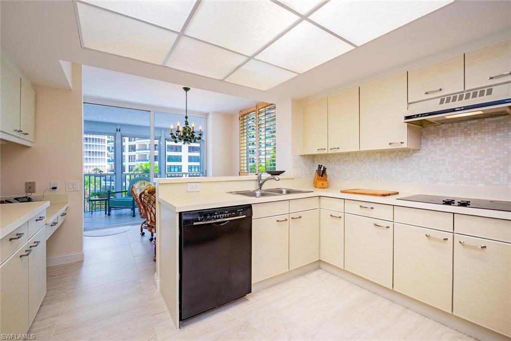 L-shaped kitchen featuring cream cabinetry, a built-in black dishwasher, and a black cooktop