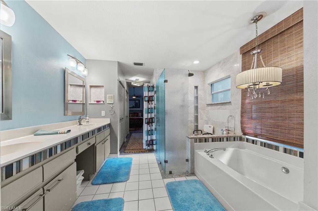 Dual vanity with undermount sinks, a walk-in shower with glass enclosure, and a built-in soaking tub