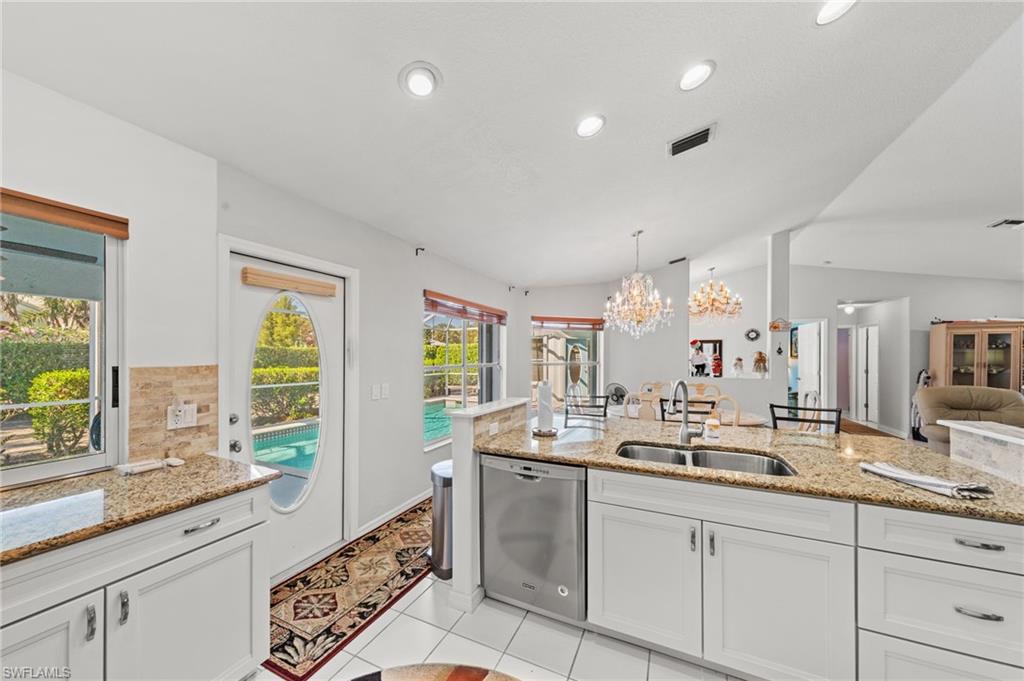 Kitchen featuring white cabinetry, granite countertops, stainless steel appliances, and a dual basin sink