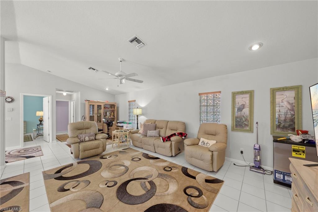 Spacious interior featuring vaulted ceilings and white tile flooring
