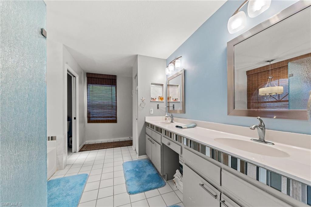 Dual vanity with integrated sinks and chrome fixtures, framed mirrors, and a textured glass shower enclosure