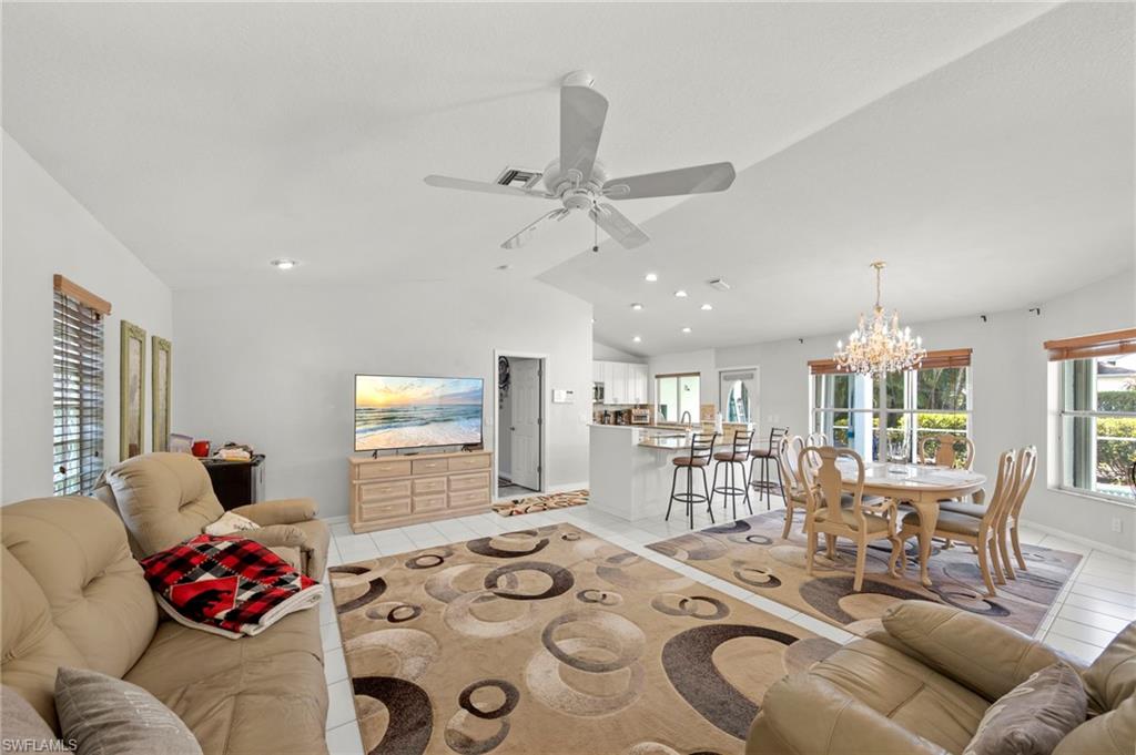 Open-concept living area with white tile flooring and recessed lighting