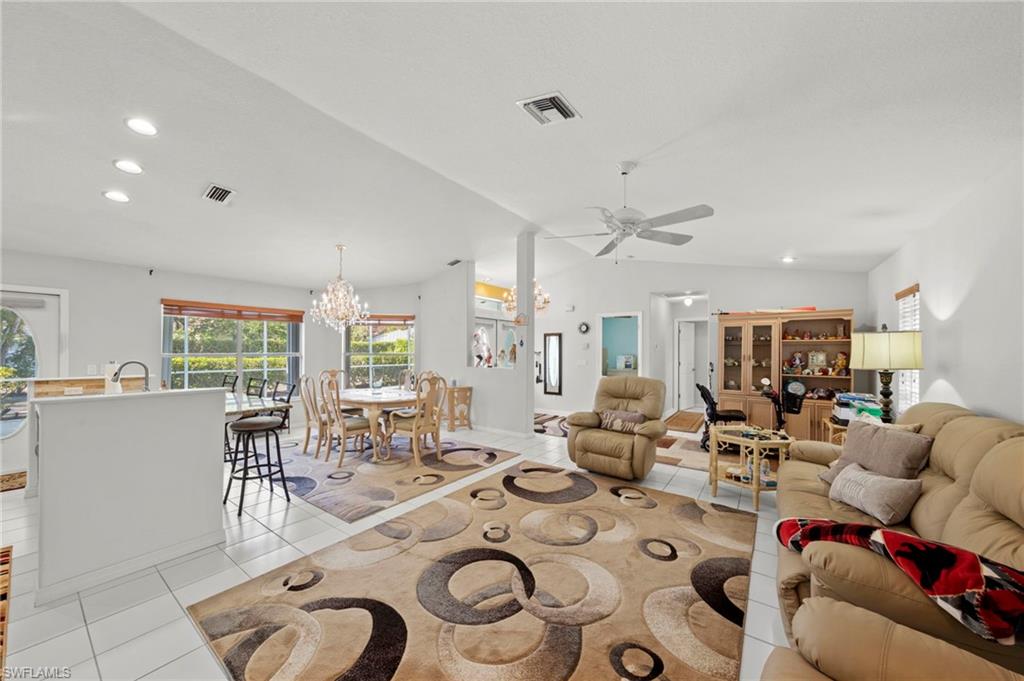 Bright interior featuring white tile flooring and vaulted ceilings