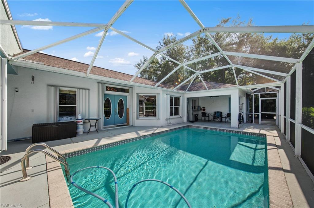 Screened lanai featuring a swimming pool with a step entry, a covered patio area, and direct access to the interior through double-oval-light doors