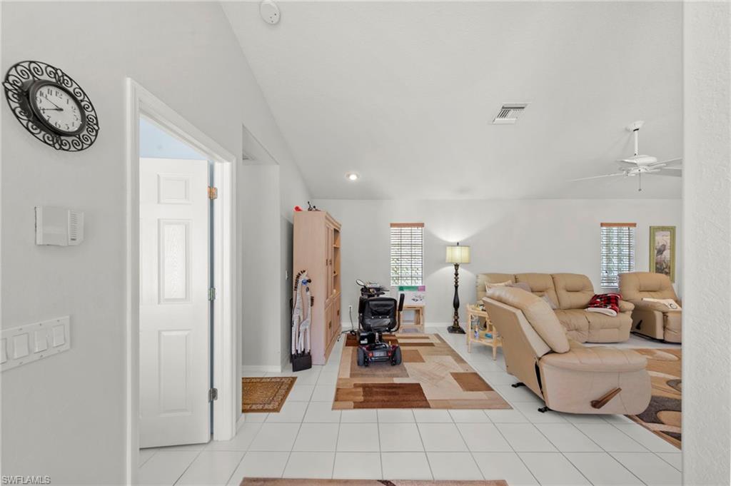 Bright interior space featuring white tile flooring, white walls, and recessed lighting