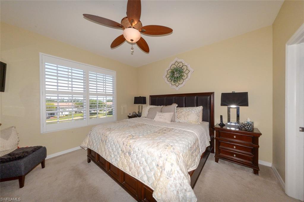 Spacious Primary Suite features large windows with Lake View, Plantation Shutters, En-suite bathroom & Large walk-in closet.