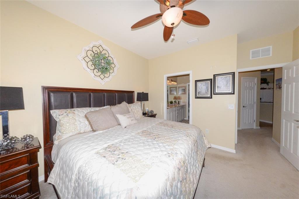 Spacious Primary Suite features large windows with Lake View, Plantation Shutters, En-suite bathroom & Large walk-in closet.