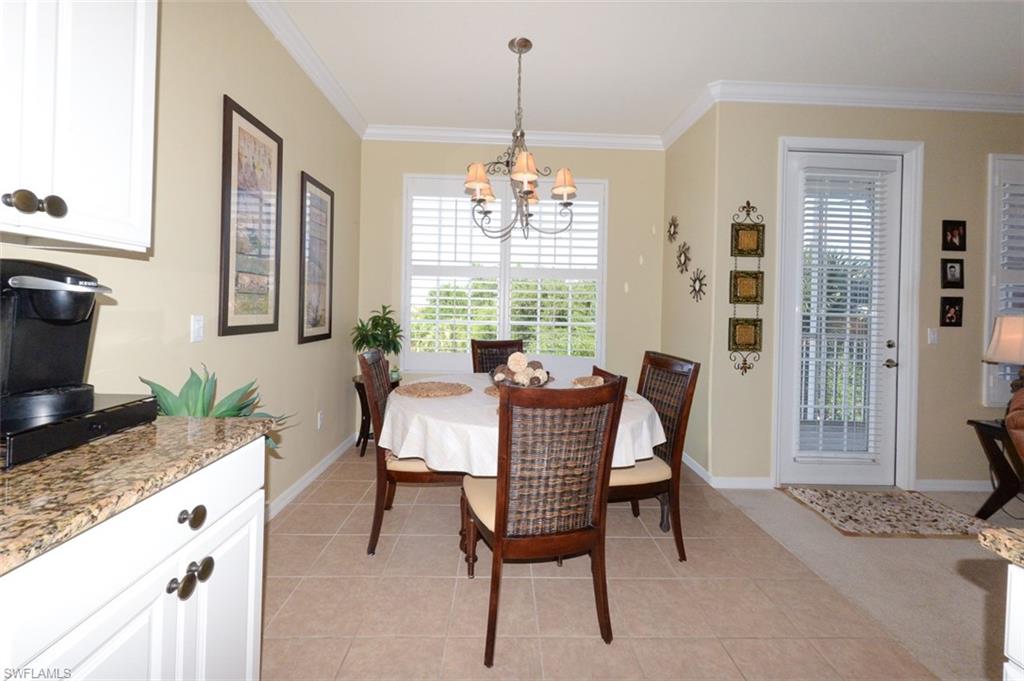 Open Kitchen looking toward dining area and door to Lanai.  Features tiled flooring, a Breakfast bar, pantry, 9'4" ceilings, Crown molding, recessed and pendant lighting, White cabinetry, beautiful Granite Countertops, Plantation shutters and more.