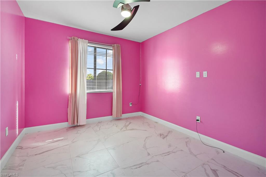 Room featuring a window with blinds and drapes, a ceiling fan, and white baseboards