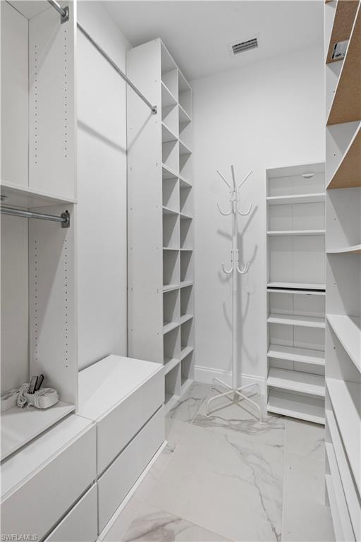 Custom closet system featuring white cabinetry and shelving