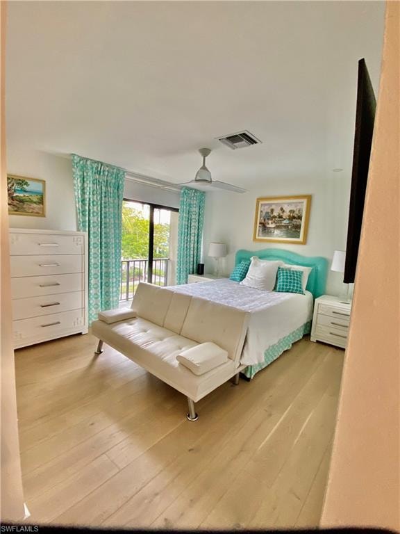 Bedroom featuring access to outside, wood finished floors, visible vents, and a ceiling fan