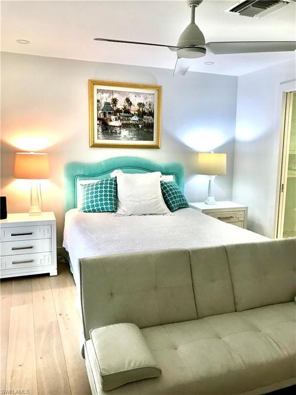 Bedroom with light wood-type flooring, visible vents, and ceiling fan