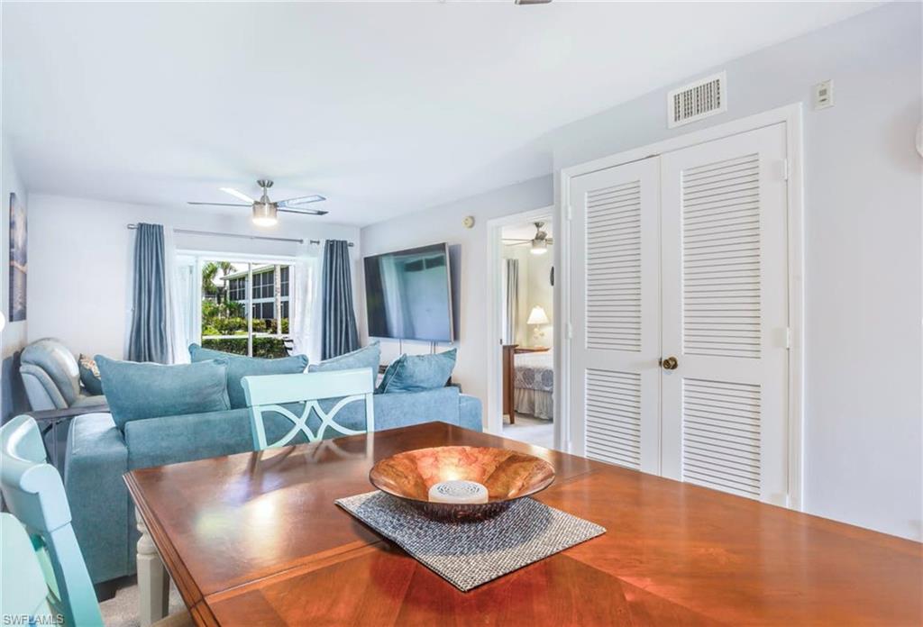 Bright living space featuring a wood-finish dining table and white louvered closet doors
