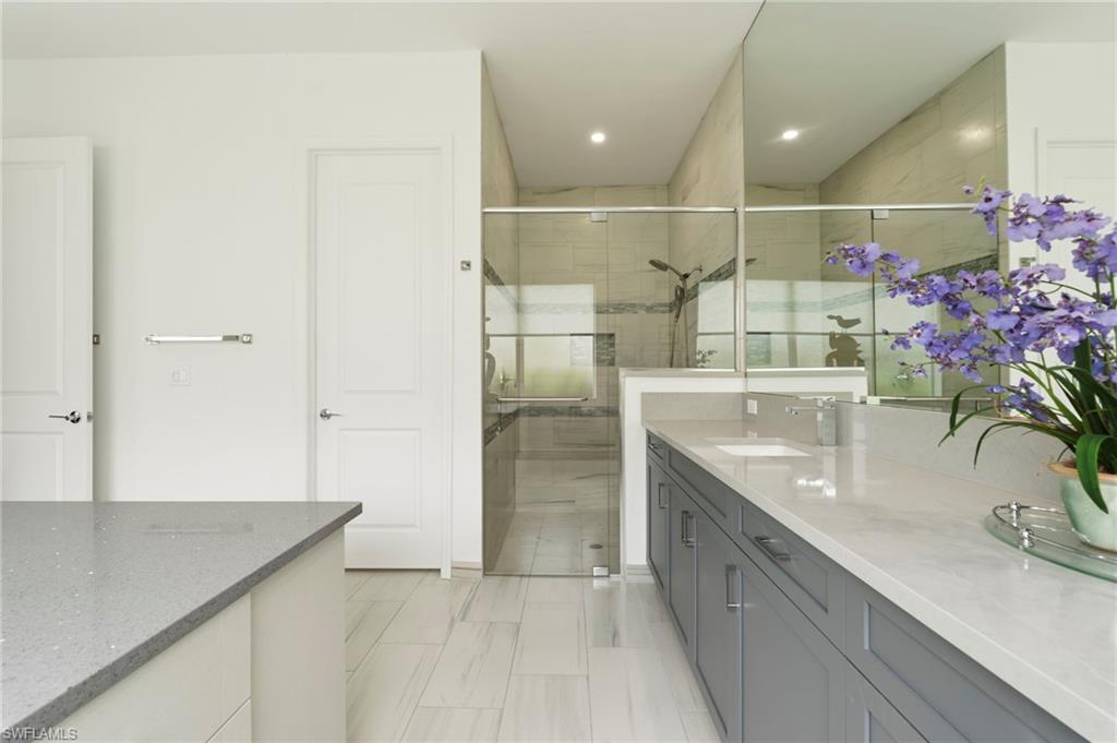 Primary bathroom suite with quartz counters, large walk-in shower, water closet