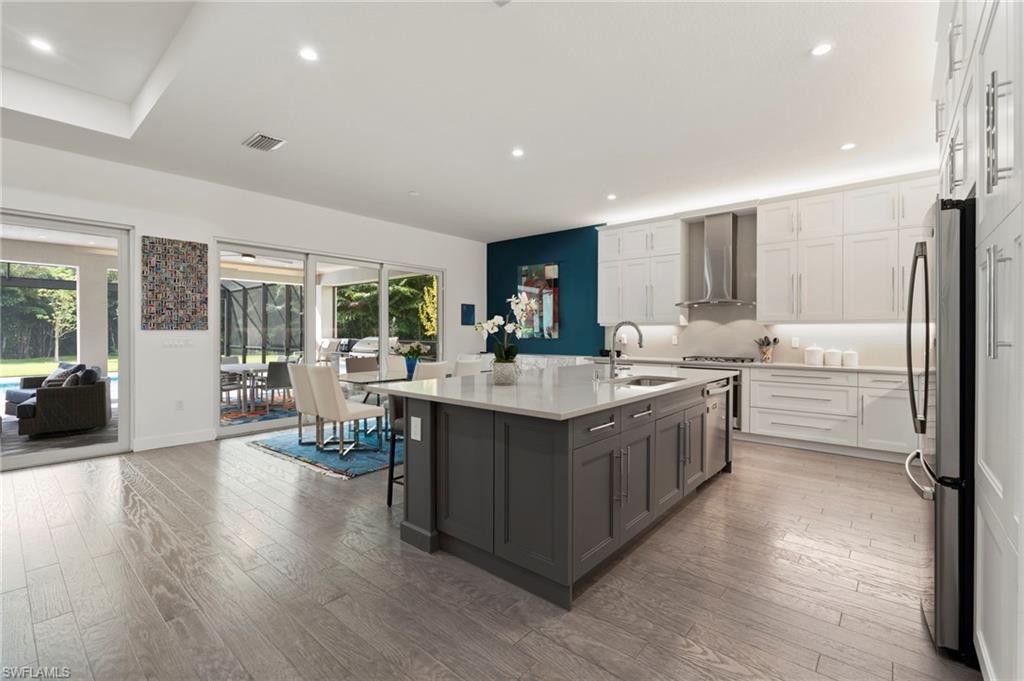 Top-of-the-line kitchen features include a vented range hood, built-in pantry, added row of top cabinets, quartz counter and backsplash, under and over cabinet lighting.