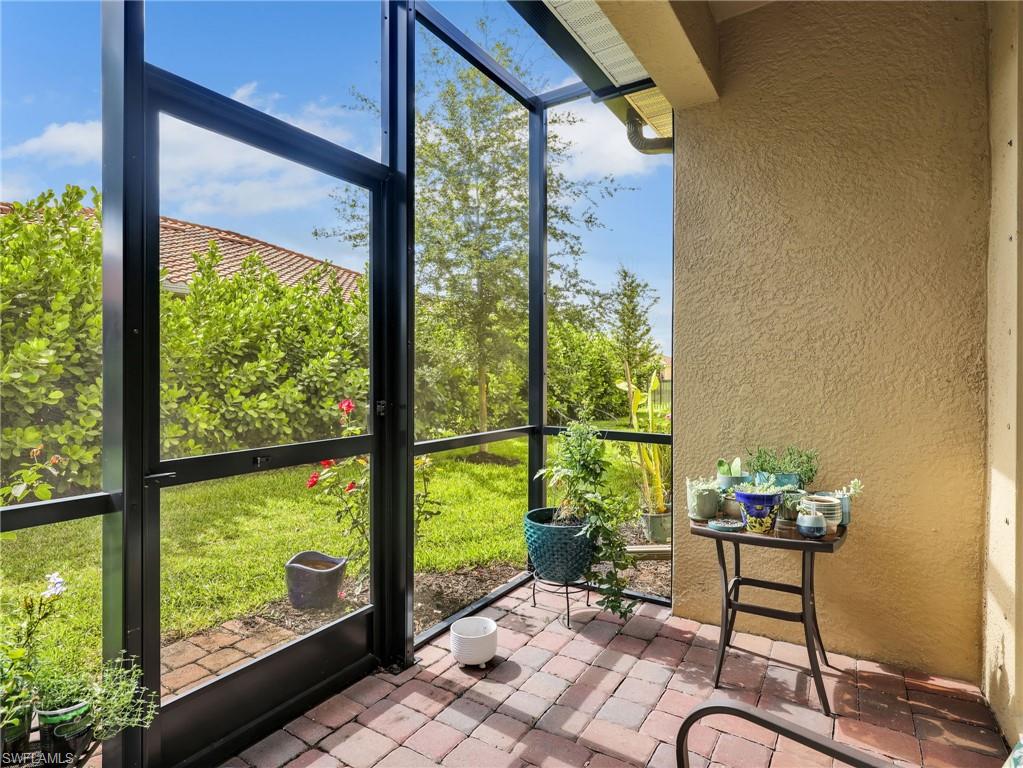 Screened patio featuring brick paver flooring, textured exterior wall finish, and a covered ceiling