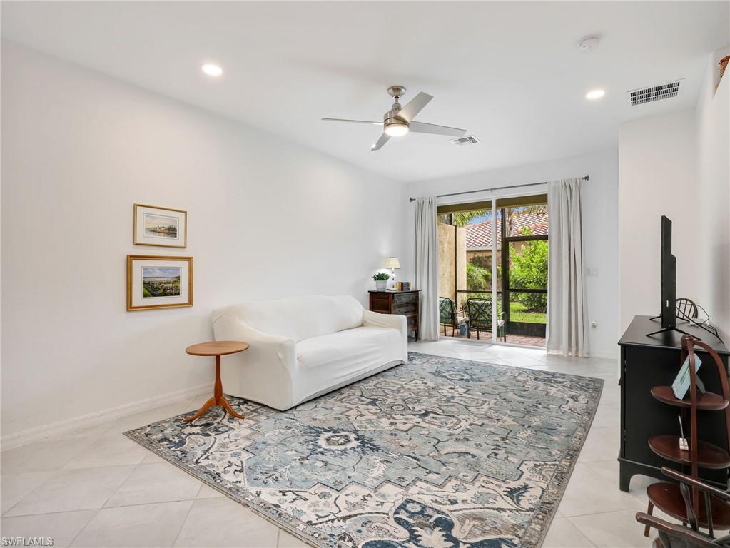 Spacious interior room featuring tile flooring, a recessed lighting array, and a ceiling fan with integrated lighting